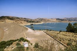 Image du Maroc Professionnelle de  Le barrage Oued El Makhazine, conçu pour le développement et  l'irrigation du périmètre du Loukkos. Ainsi les champs situés dans le triangle Ksar El Kébir, Larache, Moulay Bouselham profitent de cette infrastructure. Cette importante réalisation située sur El Oued Loukkos sert à la régularisation inter annuelle des débits tout en formant une protection contre les crues, au Jeudi 1er Septembre 2005 à cette datte le barrage dispose 309 Million de M3. (Photo / Abdeljalil Bounhar) 